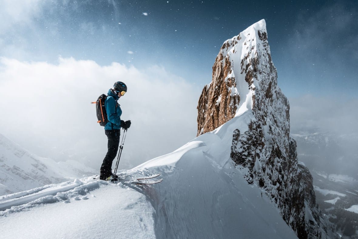 Freeride skier on high steep ridge above la Clusaz ski resort